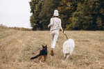 Beautiful woman walking out her dog in a field